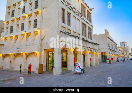 DOHA QATAR - le 11 juillet 2019 ; l'homme arabe dans une tenue habituelle au crépuscule heure repose sur sa brouette dans street en scène de Souq Waqif Banque D'Images