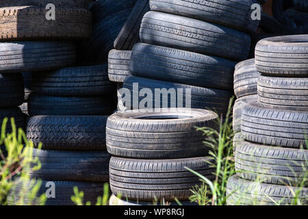 Les vieux pneus empilés, Close-up pneu endommagé, cassé un tas de vieux pneus de voitures d'occasion. La pollution de l'environnement. Pneus de vidage Banque D'Images