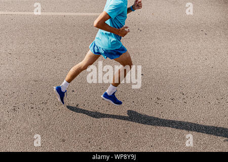 Homme runner pour courir le long de l'asphalte gris vue supérieure Banque D'Images