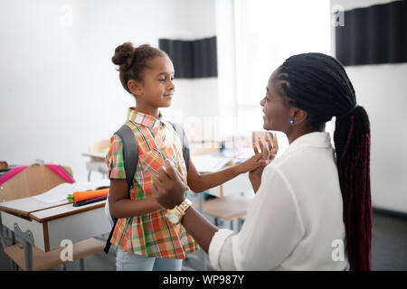 La peau sombre à l'appui de l'enseignant peu fille afro-américaine Banque D'Images
