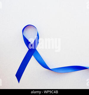 Sensibilisation bleu ruban avec trail sur fond blanc, ruban bleu foncé pour symbolique - colon cancer colorectal et le syndrome de détresse respiratoire aiguë Banque D'Images