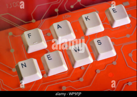 Touches du clavier forment le mot FAKE NEWS sur red electric circuit dans l'arrière-plan. Banque D'Images