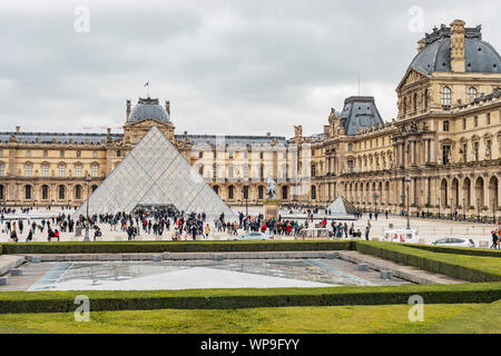 Paris, France - 28 janvier 2018 : les touristes se sont rassemblés devant l'entrée du musée du Louvre dans la cour intérieure du palais et de pluie jour nuageux. Banque D'Images