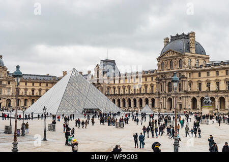 Paris, France - 28 janvier 2018 : les touristes se sont rassemblés devant l'entrée du musée du Louvre dans la cour intérieure du palais et de pluie jour nuageux. Banque D'Images