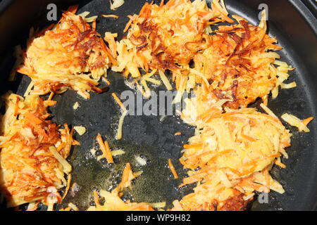 De délicieuses crêpes de pomme de terre sont frits dans une casserole Banque D'Images