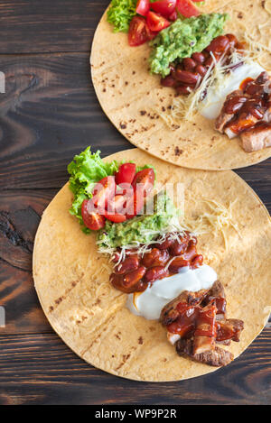 Les tacos avec des remplissages sur la table en bois Banque D'Images