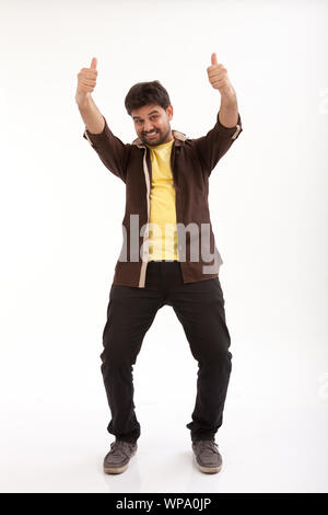 Portrait of a young man showing Thumbs up signs Banque D'Images