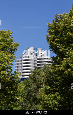 La tour BMW vue à travers les arbres, siège de BMW, Munich, Bavière, Allemagne. Banque D'Images