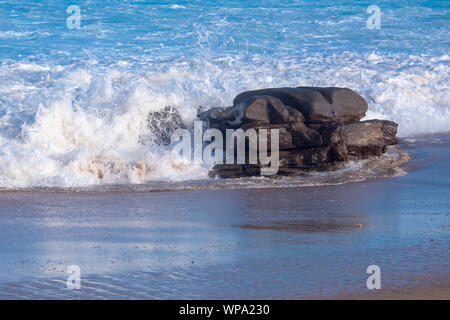 Marée est en. Cercle vicieux des vagues avec la marée montante s'écraser sur le rivage avec un très fort ressac. Le surf est mousseux le soleil de l'après-midi. Banque D'Images