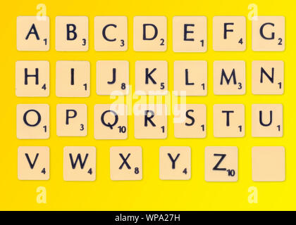 Créé numériquement image d'un alphabet complet de scrabble carreaux sur fond jaune Banque D'Images