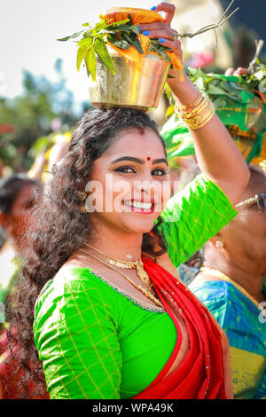 Lewisham, Londres, Royaume-Uni. 08 Sep 2019. Une jeune femme tient un pot rempli de lait sur sa tête comme offrandes aux dieux. Les fidèles célèbrent le festival annuel Tamil chariot (Ther) avec une procession. Les visiteurs se mêlent aux participants tandis que la procession colorée serpente dans la banlieue londonienne depuis le temple Sivan Kovil de Londres. Crédit : Imageplotter/Alamy Live News Banque D'Images