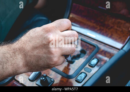 Chauffeur Homme hand holding transmission automatique en voiture. La main des hommes en changement du niveau de la boîte de vitesses automatique dans la voiture. Le transport. Banque D'Images