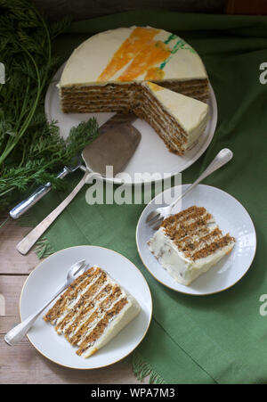 Le gâteau aux carottes, des morceaux de gâteau à la crème de fromage et des carottes sur un fond de bois. Style rustique. Banque D'Images