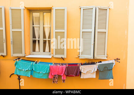 Vieux bâtiment orange avec grande fenêtre et choses humides Banque D'Images