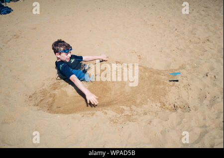 Garçon dans le sable à Frensham, Grand Étang, Farnham, Surrey, Angleterre, Royaume-Uni. Banque D'Images