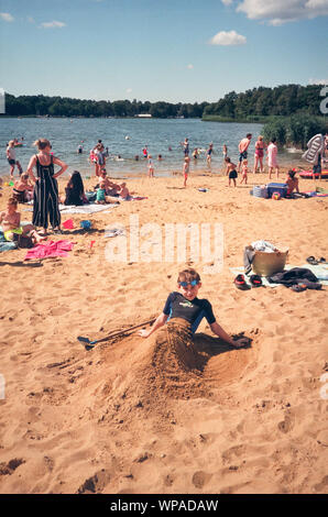 Garçon dans le sable à Frensham, Grand Étang, Farnham, Surrey, Angleterre, Royaume-Uni. Banque D'Images