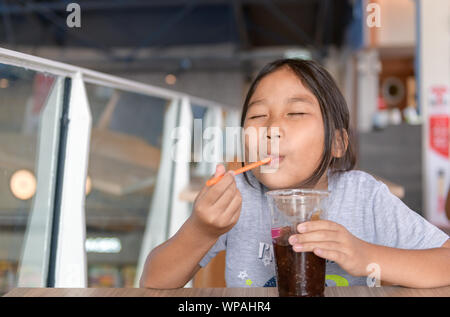 Happy girl drinking cola de Smoothie tasse en plastique dans un dépanneur, un concept de restauration rapide Banque D'Images