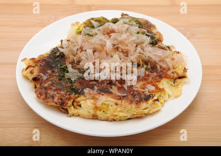 Okonomiyaki crêpe japonais sur la plaque alimentaire isolé sur le tableau Banque D'Images