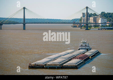 Le trafic des barges sur le fleuve Mississippi au nouveau pont de la rivière du Mississippi le 28 août 2019 à St Louis, Missouri, USA. Une barge typique comporte 1500 tonnes de marchandises, qui est 15 fois supérieure à une voiture de chemin de fer et 60 fois plus grand que un camion-remorque. Une rivière moyenne tow sur le fleuve Mississippi est composé de 5 barges 15 chalands attachés ensemble et déménagement 3 au courant. La même charge aurait besoin d'un train 3 milles de long ou file de camions s'étend sur plus de 35 kilomètres. Banque D'Images