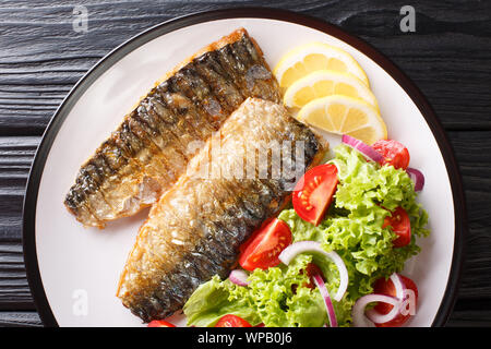 Partie de filet de maquereau grillé au citron et salade de légumes frais sur une assiette sur la table. Haut horizontale Vue de dessus Banque D'Images