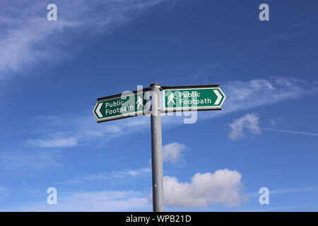 Les panneaux indiquant la direction de l'emprise des sentiers publics dans la campagne anglaise, ensemble contre le ciel bleu avec des nuages. Banque D'Images