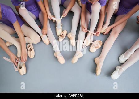 Petites ballerines mettant des chaussons. Banque D'Images