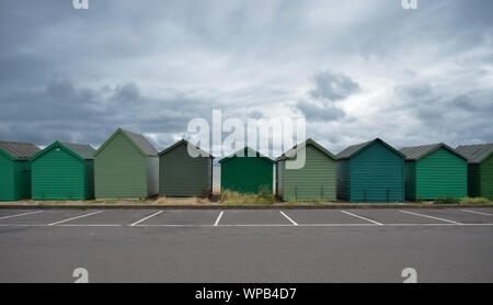 Cabines de plage en bois peint vert à rue à côte Englands Banque D'Images