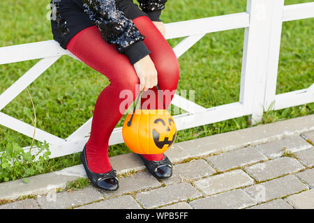 Portrait de la section basse méconnaissable girl holding pumpkin panier tout en tour ou traitement à l'Halloween, copy space Banque D'Images