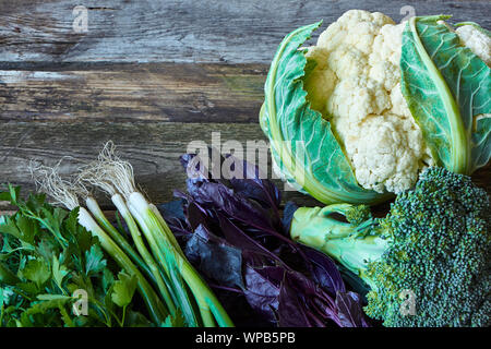 Aneth, persil frais de la ferme, les jeunes oignons, basilic rouge, brocoli et chou-fleur sur l'ancien en bois, surface rugueuse la saine alimentation concept, selective focus Banque D'Images