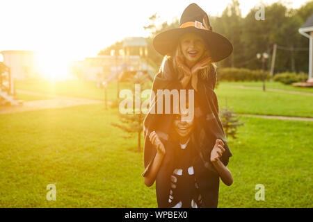 Portrait de deux petits enfants espiègles, garçon et fille, de s'amuser en plein air sur l'Halloween et faire des grimaces à la caméra à la fois, portant les costumes, copy space Banque D'Images