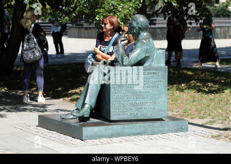 Pologne Varsovie - touristes posent pour des photos à côté de monument à Jan Karski WW2 agent secret et de messagerie à l'extérieur Musée POLIN dans le Ghetto de Varsovie Banque D'Images