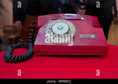 Contactez-nous .concept still life with retro téléphone rouge sur rouge sur la table en bois grunge fond antique vintage rouge .composition téléphonique analogique ou Banque D'Images