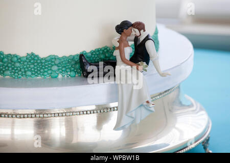 Cake topper sur le gâteau de mariage avec couple interracial. Banque D'Images
