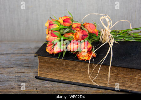 Bouquet de roses orange avec du raphia sur bow vintage Bible Banque D'Images