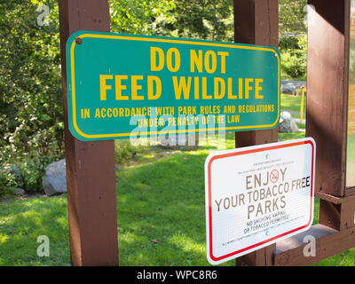 Les panneaux d'avertissement dans un local County Park dans le New Jersey Avertissement de ne pas nourrir les animaux sauvages ou à la fumée. La mise en garde aucun signe du tabac comprend vaping aussi. Banque D'Images