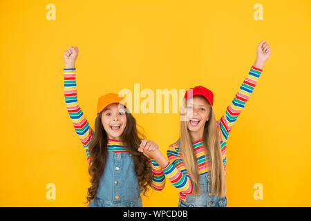 Gagnants d'atteindre leur but. Heureux les petits enfants faisant des gestes gagnant sur fond jaune. Gagnants petit mignon jouissant de bonheur. Heureux gagnants célébrant la victoire ou le succès ensemble. Banque D'Images