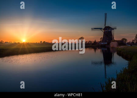 Coucher de soleil derrière un 17e siècle Driemanspolder moulin Banque D'Images