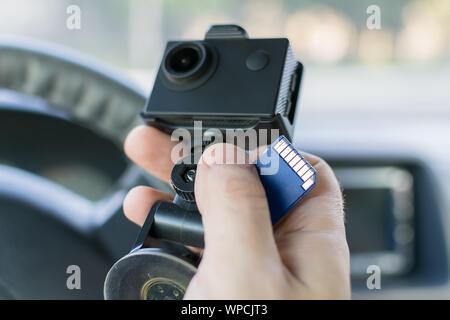 La main d'un conducteur de voiture de mâles qui détient une voiture DVR enregistrement des incidents et une carte mémoire pour elle Banque D'Images