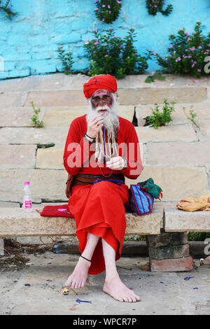 Un Sadhu albinos assis sur les ghats de Varanasi, Inde. Banque D'Images
