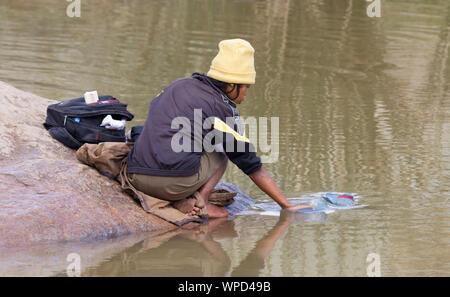 Méconnaissable femme faire la lessive dans une rivière, à Madagascar Banque D'Images