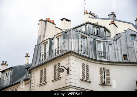 Multi-résidentiel maison en pierre avec des volets en bois et d'appartements dans les combles avec gaine métallique fenêtres et cheminées de toit situé sur l'une des Banque D'Images