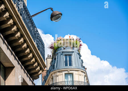 Cône arrondi appartements résidentiel Maison à étages avec des volets en bois et des combles et d'un balcon et de plantes sur le toit situé sur l'une Banque D'Images