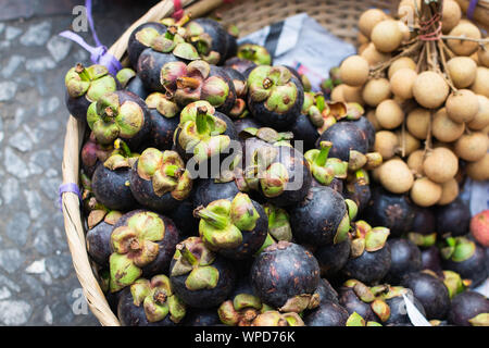 Panier de fruits exotiques frais et de mangoustan longane sur le marché asiatique Banque D'Images