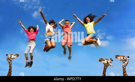 Happy kids group sauter plus haut que la tête des girafes Banque D'Images