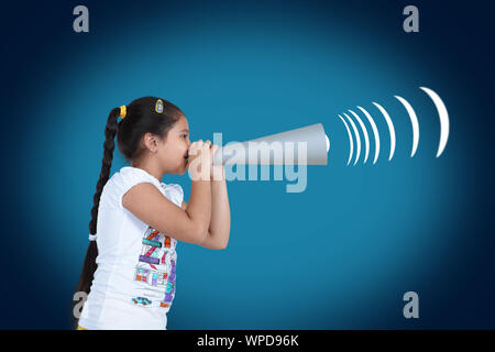 Girl shouting into a paper megaphone Stock Photo