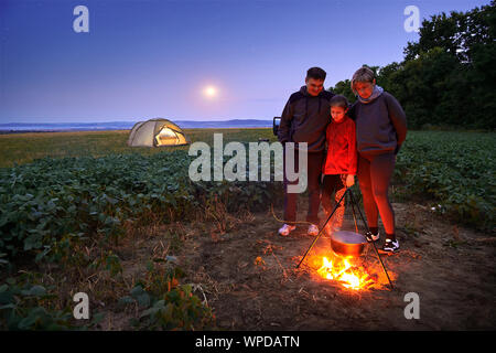 Famille et camping, crépuscule, la cuisson sur le feu. Belle nature - Domaine, forêt, les étoiles et la lune. Banque D'Images