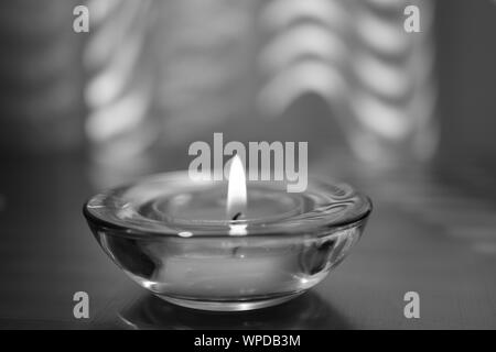 Bougie brûle dans un chandelier en verre rond sur la table, P.C. Banque D'Images