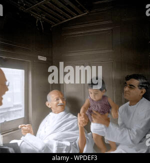 Mahatma Gandhi jouant avec enfant dans un compartiment de train, Maharashtra, Inde, Asie, 1941 Banque D'Images