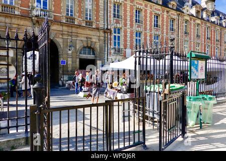 Les vendeurs mis en place dans le cadre de la vente de tentes sur une assortis occupé dimanche matin à la Place des Vosges dans le Marais, Paris, France. Banque D'Images