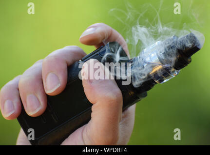 Un E Cigarette / Mod dans la main d'un homme vaping la photo en gros Banque D'Images